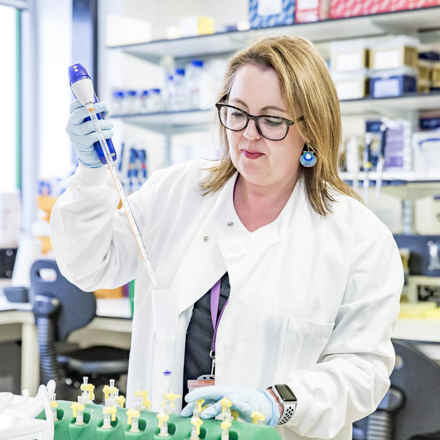 Researcher Amanda Carr in laboratory with syringe