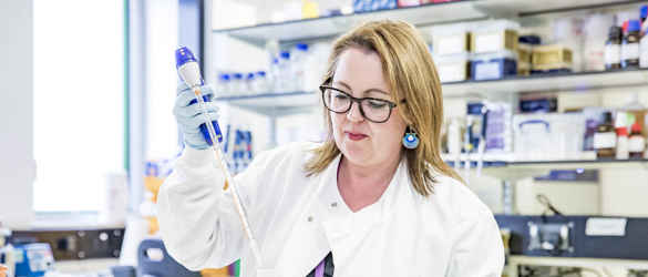 Researcher Amanda Carr in laboratory with syringe