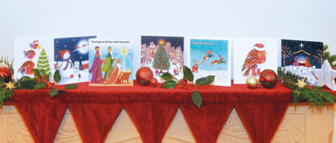 Christmas card designs on a decorated mantle