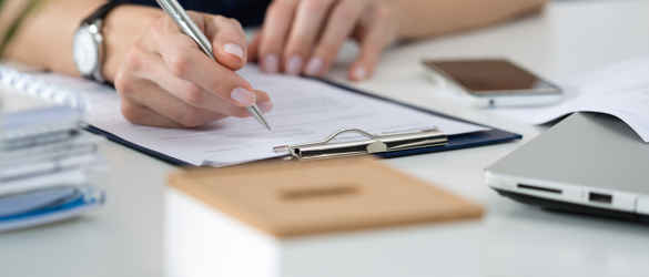 Woman writing on clipboard