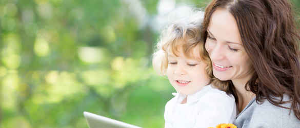 mother and young daughter with flowers looking at tablet