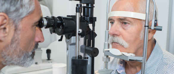 Man having eye test, leaning into eye examination machine.