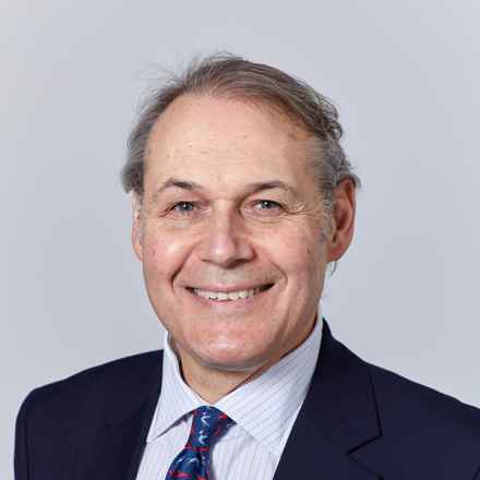 Headshot of professor Paulo Stanga, a white male with grey hair, smiling, wearing a suit and looking at camera.
