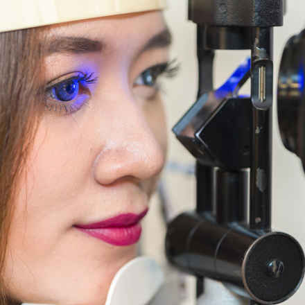 Woman having eye test with blue light.