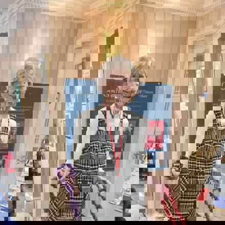 Rita, a white woman in her 80s with short grey hair smiling to camera