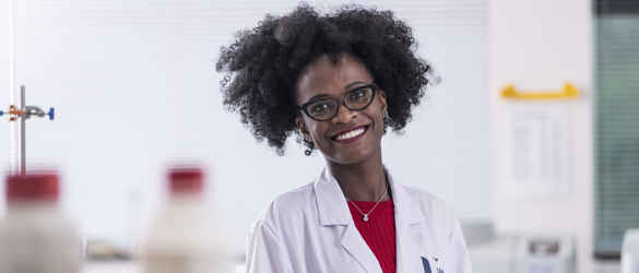 Oduor Poullette smiling in white lab coat