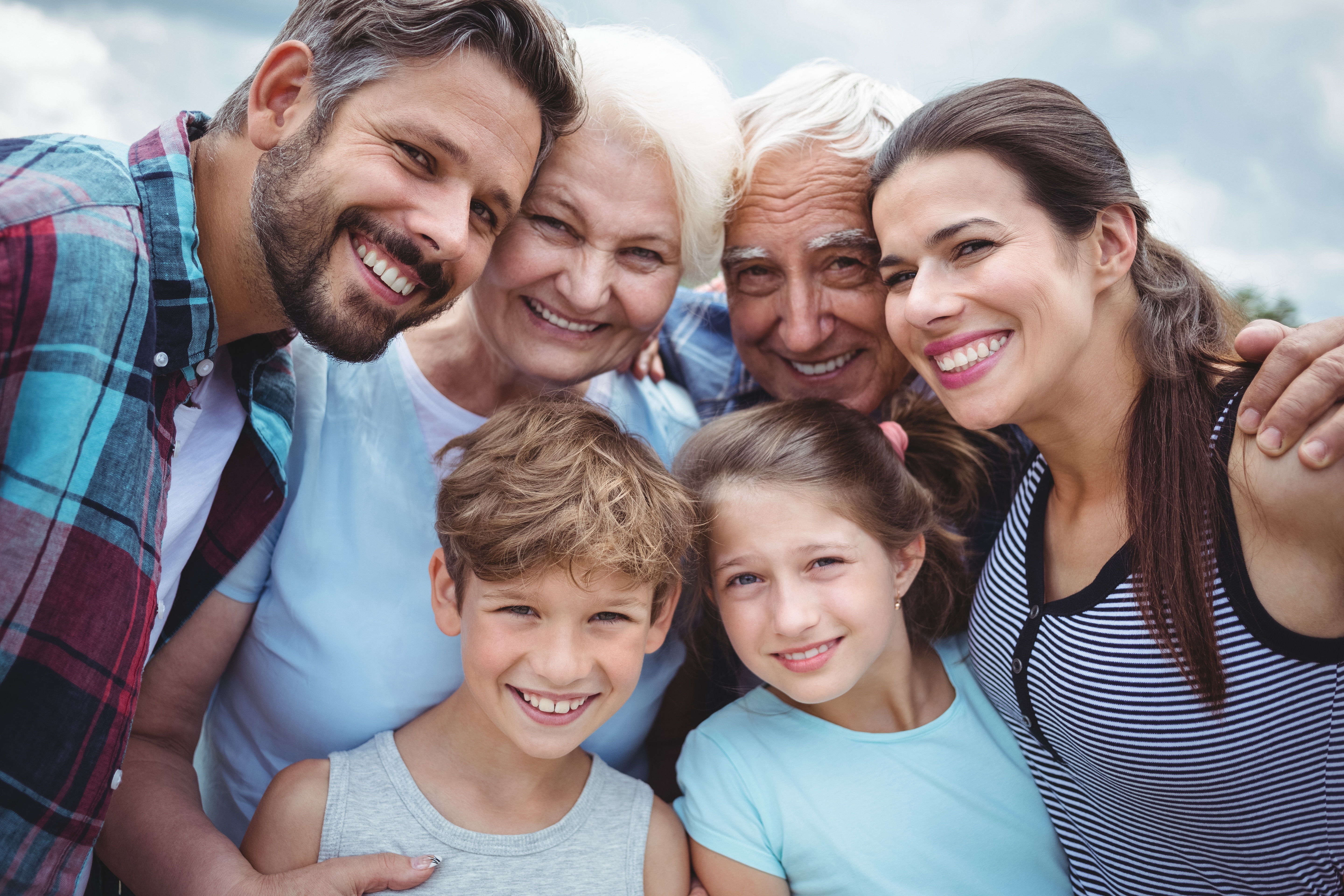 Family hugging and smiling at camera