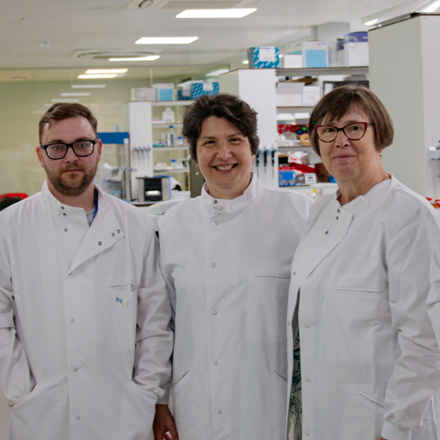 three scientists in white coats