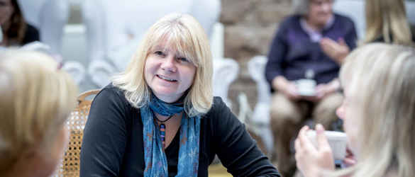 Group around table smiling with tablets
