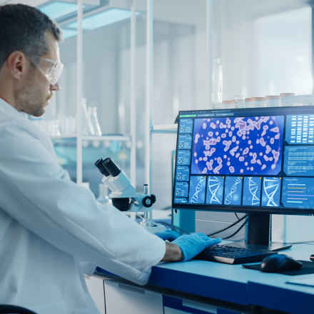 Researcher looking at a computer with DNA and RPE cells