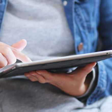 Individual reading a tablet